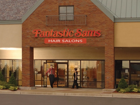 A brick building with the bright orange Fantastic Sams logo on it.